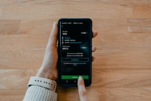 manos utilizando el celular realizando una transaccion de dinero