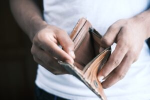 manos sosteniendo cartera vacia por sobreendeudamiento